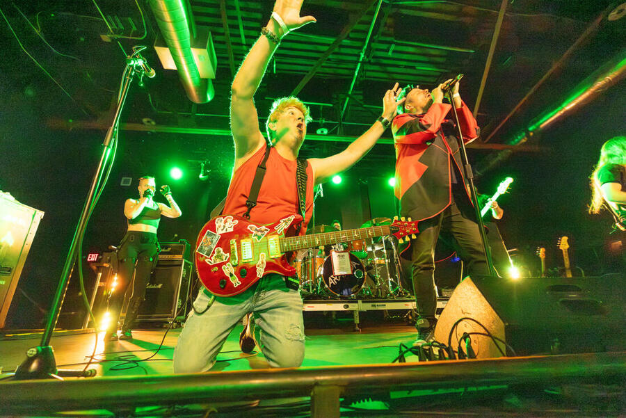 Adam DeGraide on his knees at the front of the stage