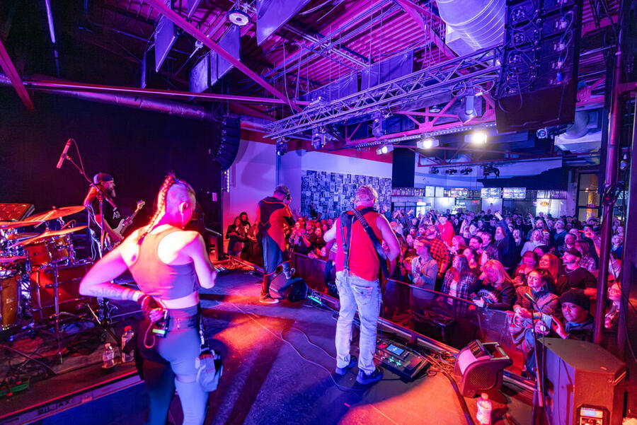 The band from behind, facing a full room